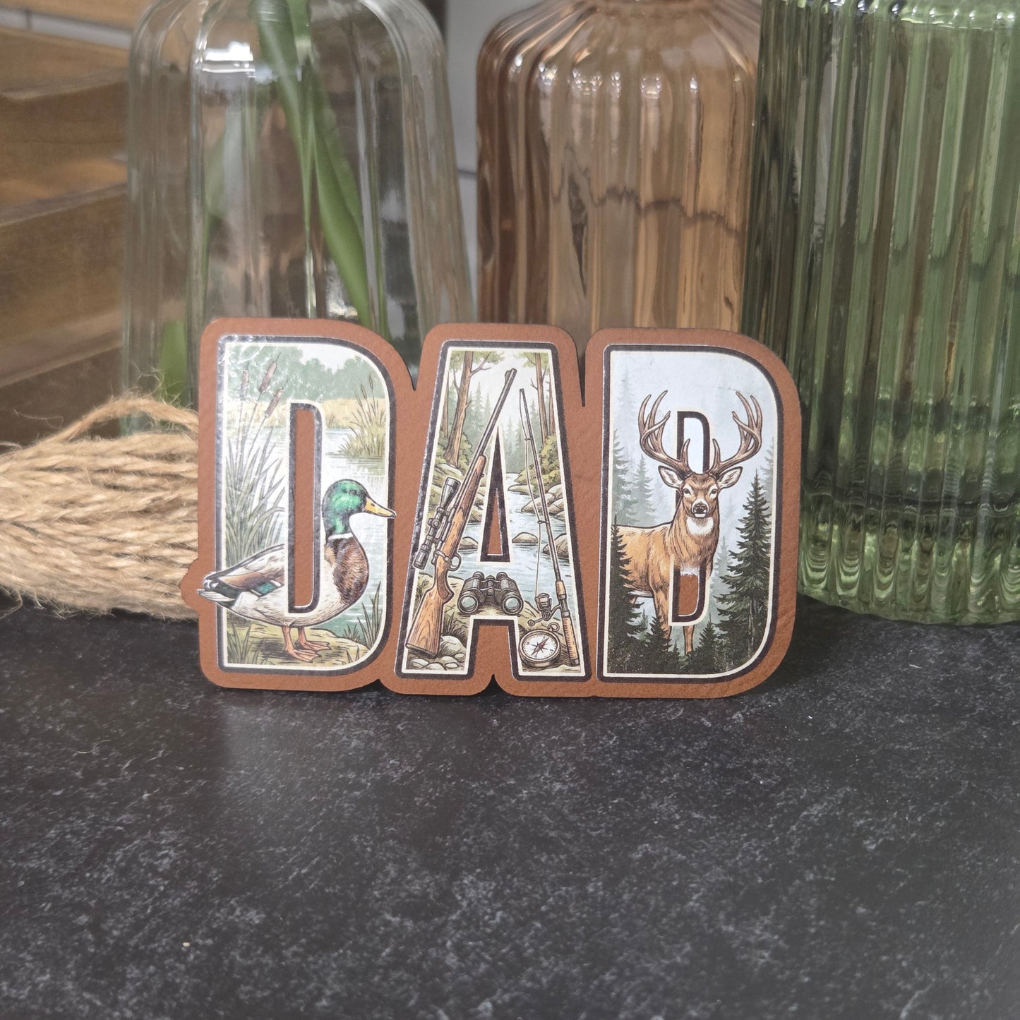 Decorative UV Printed Leatherette spelling 'DAD' with nature-themed designs on a Rawhide Leatherette.
