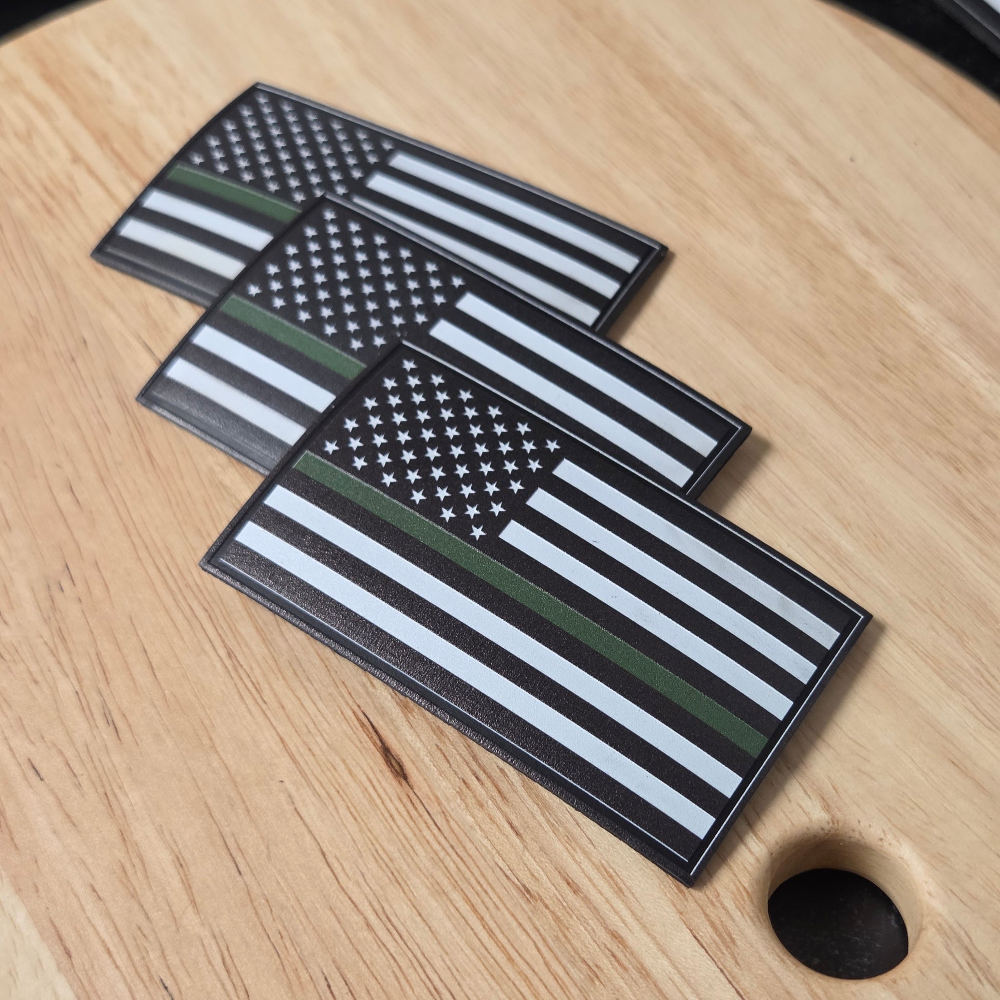 Three flag-themed patches on a wooden surface